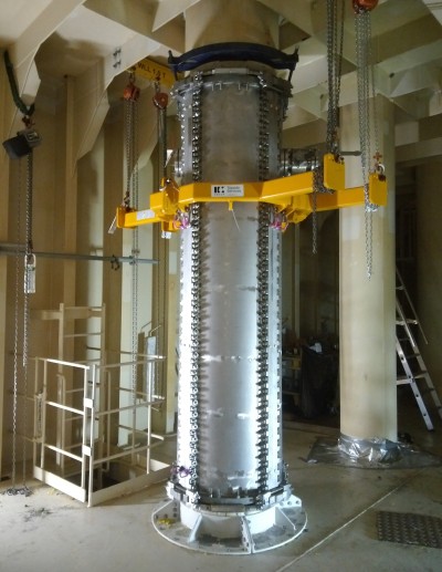 A large metal pipe inside a building with a yellow Super Duplex Pipe Clamp on it